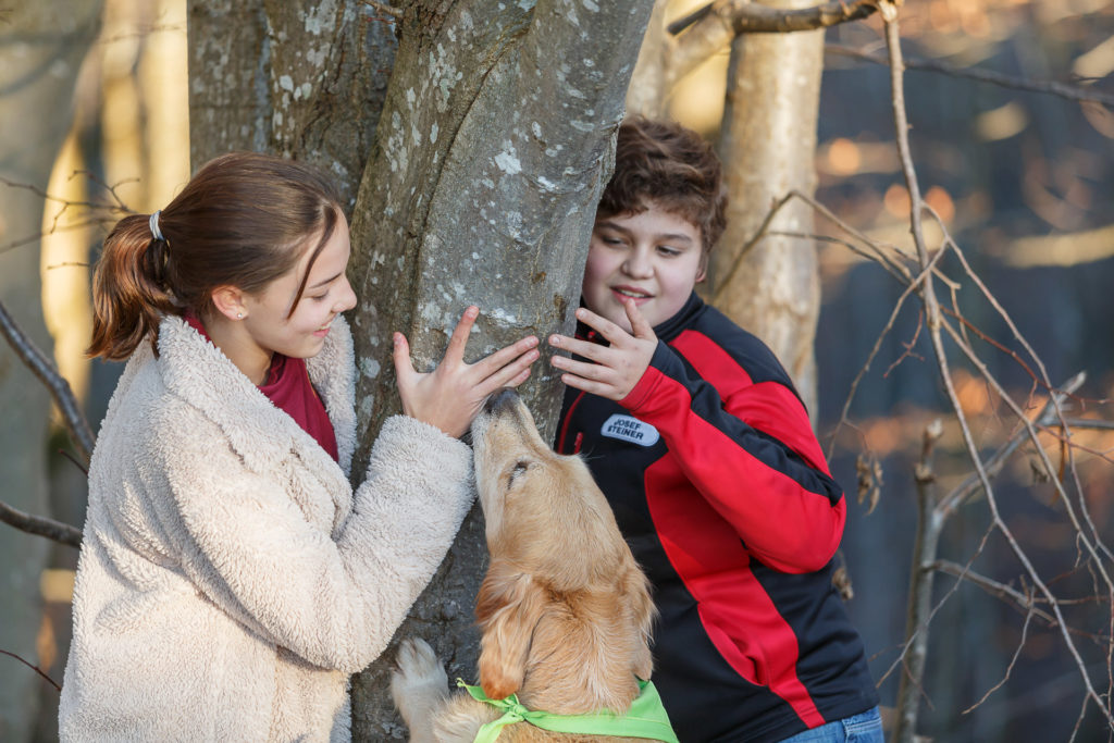 2 Kinder und Hund Timber neben einem Baum